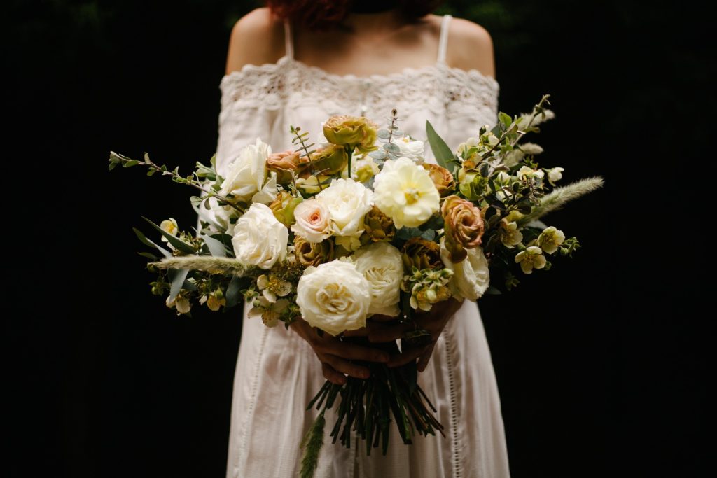 Woman in wedding dress with bouquet of flowers